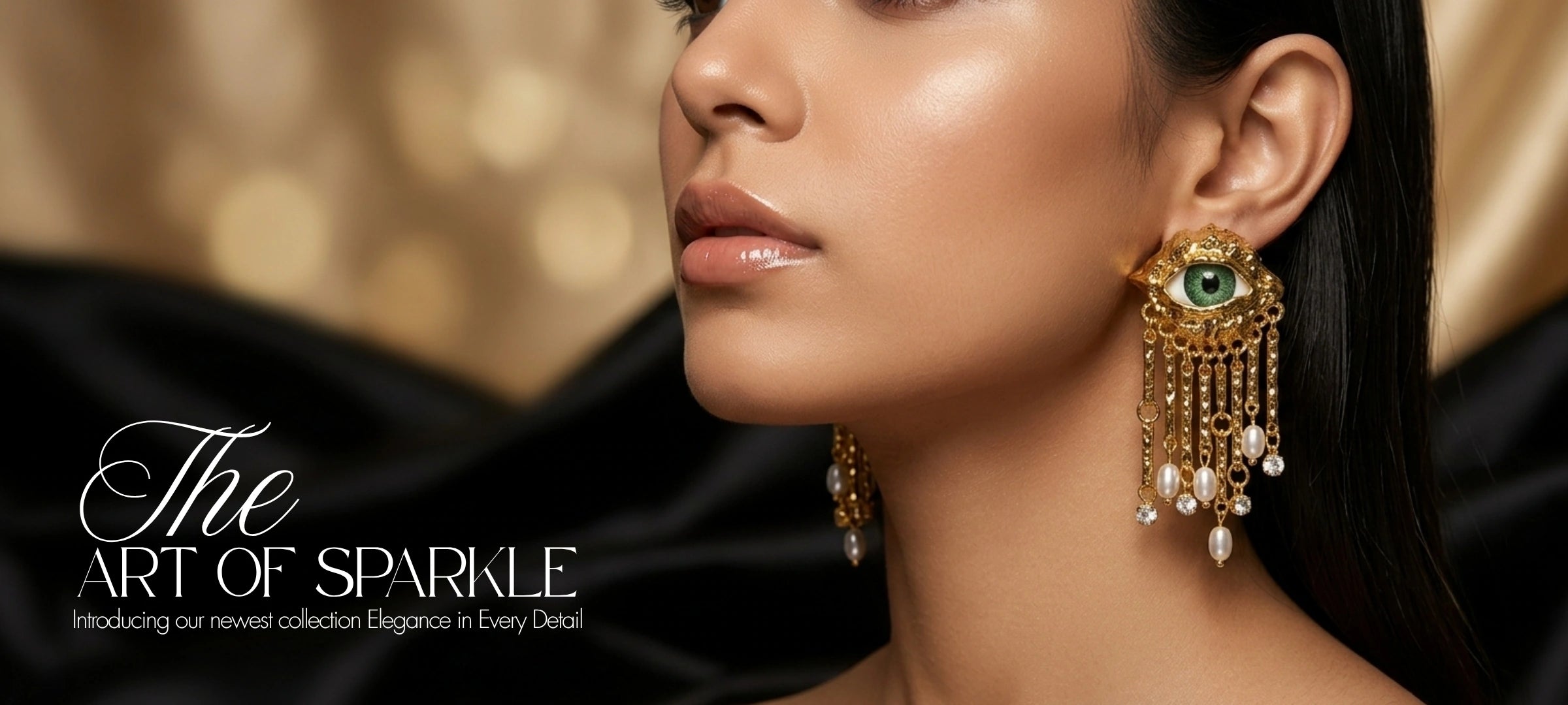 A close-up side profile of a woman wearing an ornate gold dangle earring with a green stone and pearl-like drops, against a dark draped fabric and warm gold bokeh background. Text on the left reads 'The ART OF SPARKLE'.